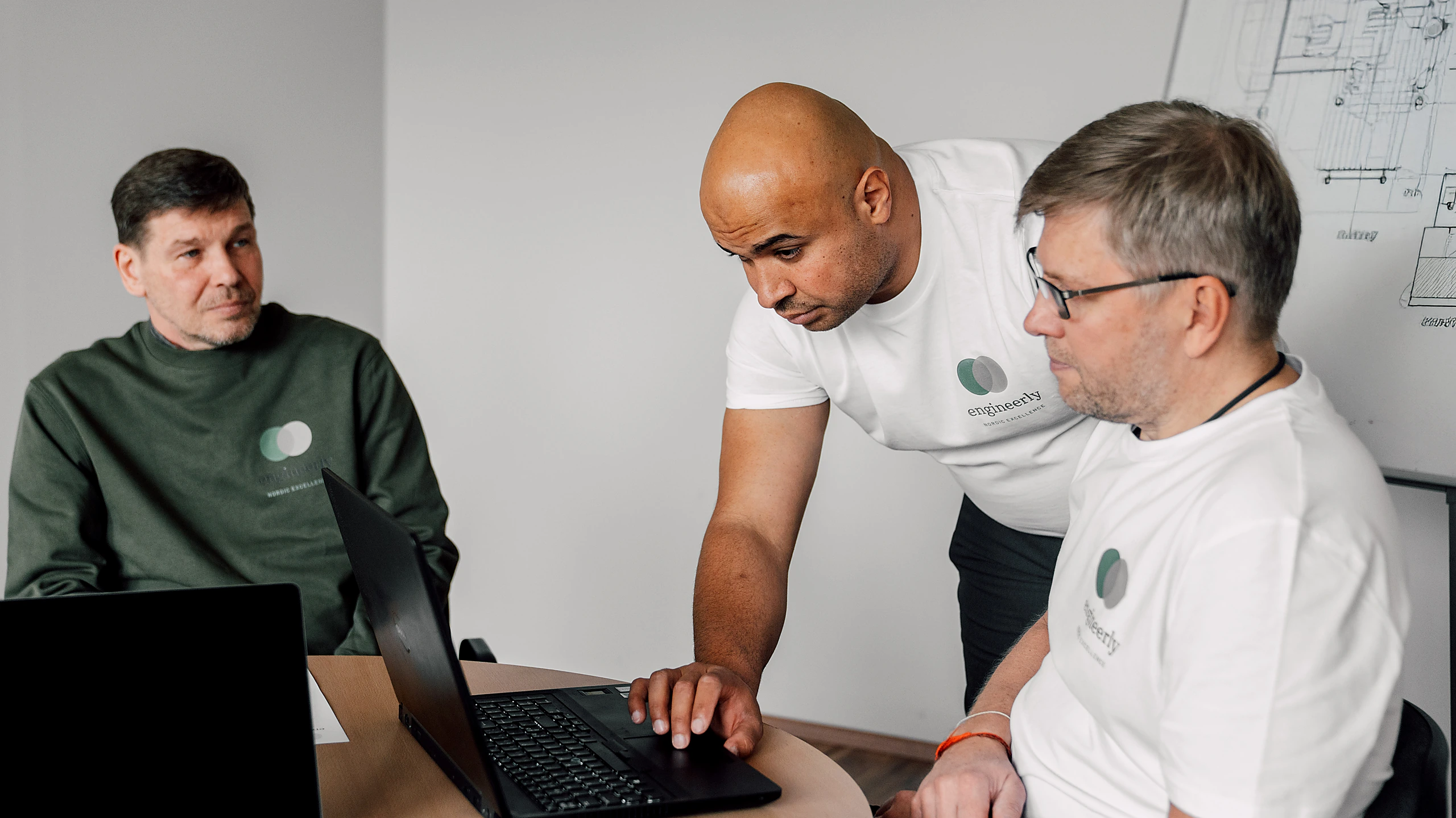Engineers reviewing work together at a laptop.